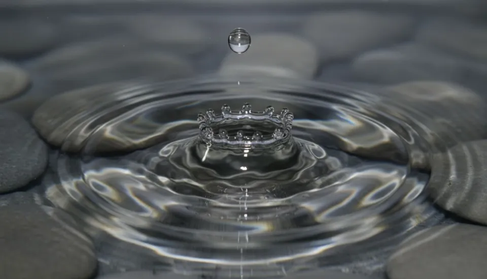 AI-generated water droplet creating perfectly symmetrical ripples demonstrating physics-accurate fluid simulation